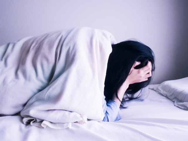 ひどい頭痛で悩む女性
